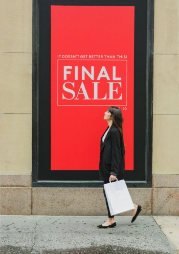 Woman walking by Red Sale Sign